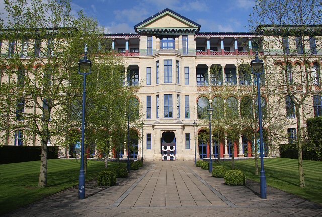 The courtyard entrance of Cambridge Judge Business School, home of Cambridge Social Ventures, with the drawn Social Pathfinder signpost in the foreground